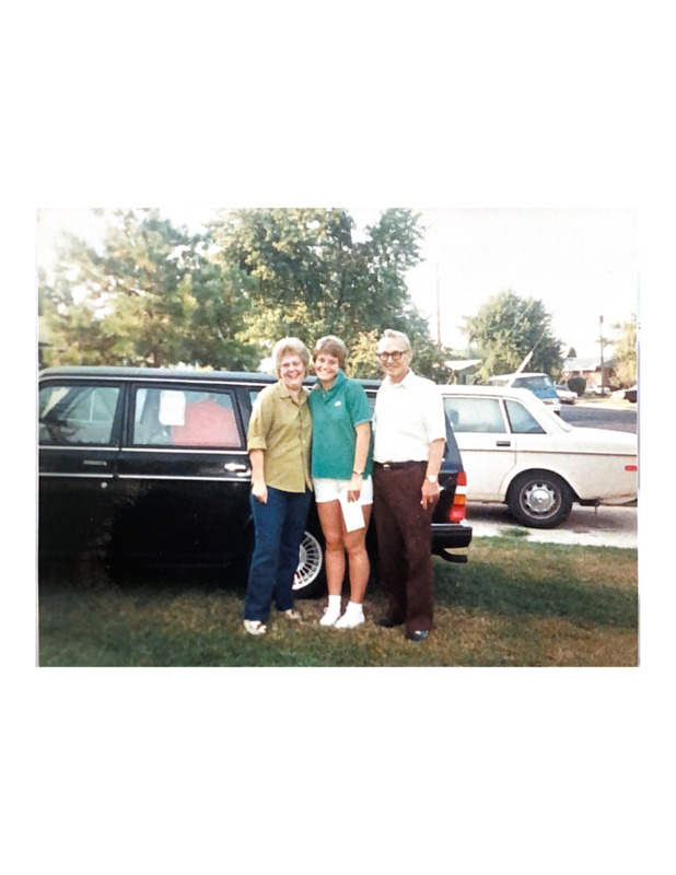 Scan of a color photograph of Jackie and John Turpin with their daughter Lisa, who left for college that day. Behind them is a dark car that appears to be packed with Lisa's belongings. 