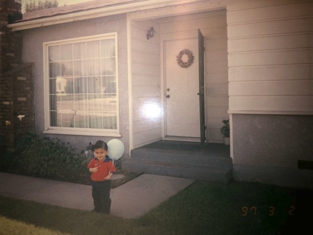 Little David is posing in front of the family's West Covina home, holding a blue ballon.