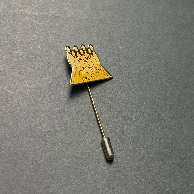 image of a lapel stickpin featuring ten bowling pins as if standing at the end of a bowling lane. "WIBC League Special Award" are inlaid in a gold metal. The entire pinhead has a clear, resin-like coating on top.