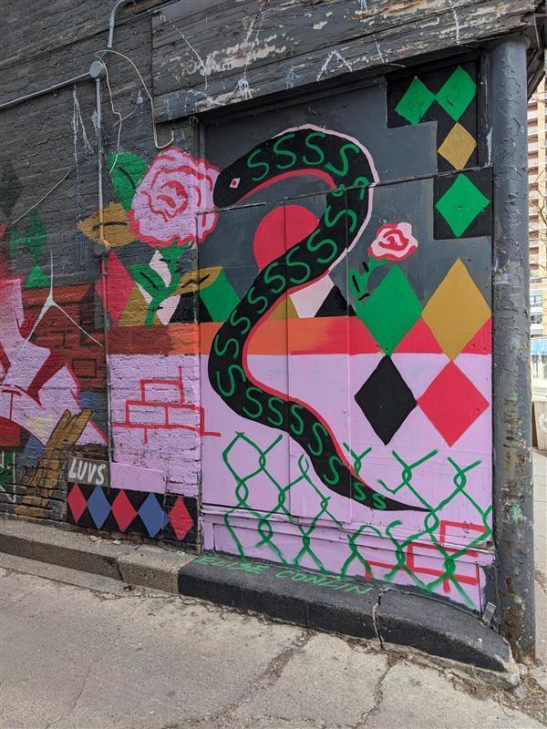 A snake and various shapes in bright colours on the side of a thrift store.