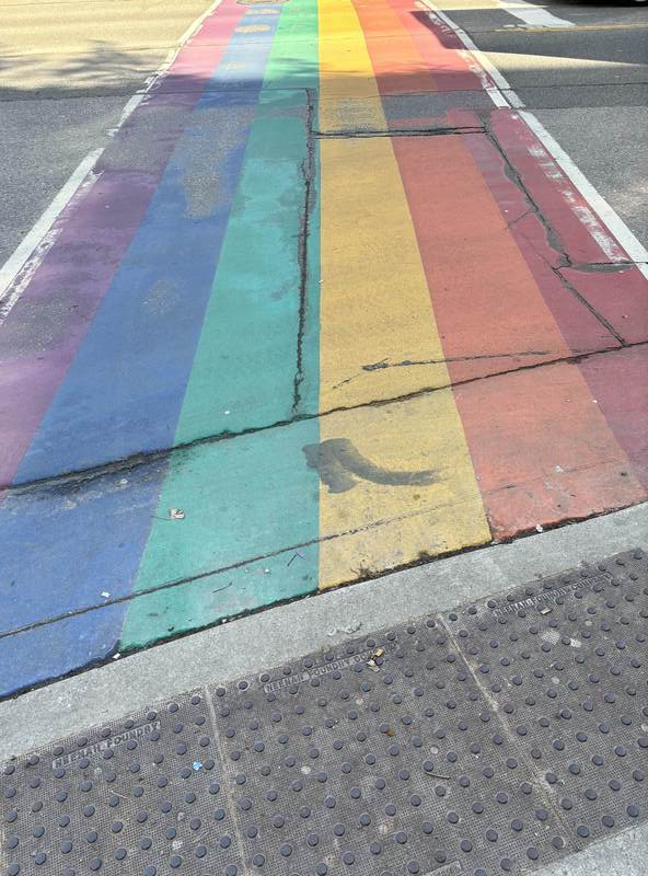 A cracking rainbow painted crosswalk