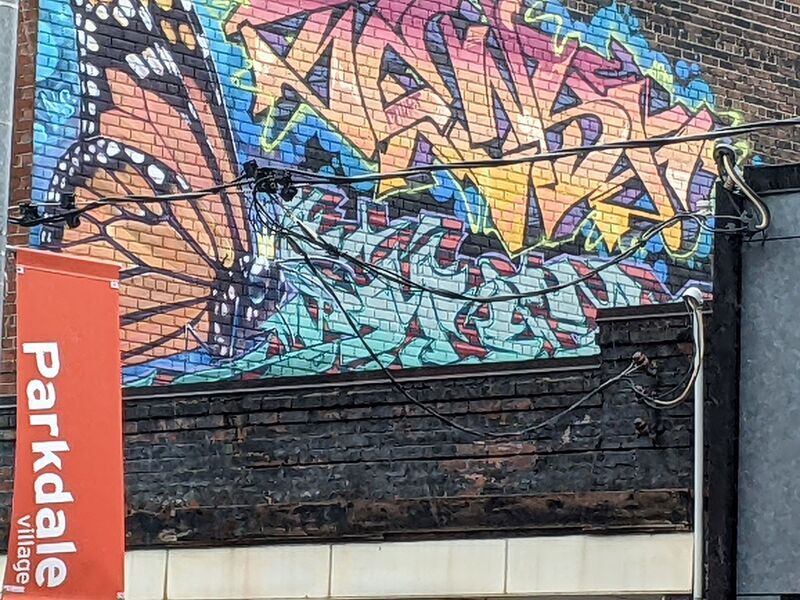 A butterfly surrounded by a brightly coloured graffiti.