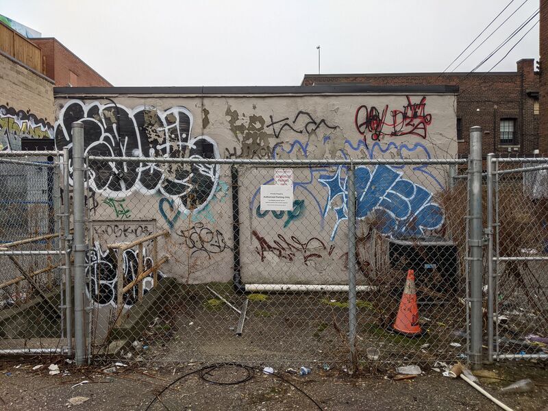 Tags on a wall in a fenced off area.