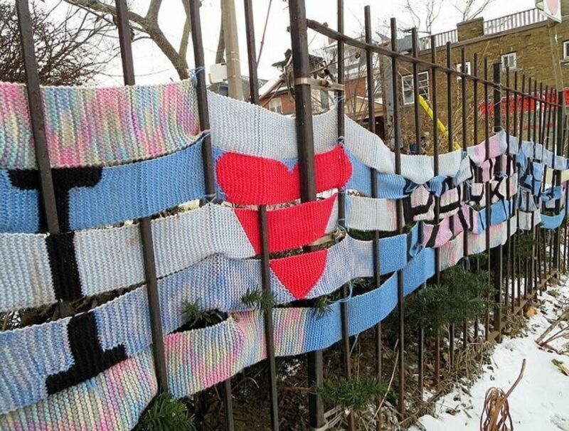 A fence with scarves weaving through spelling "I <3 Parkdale"