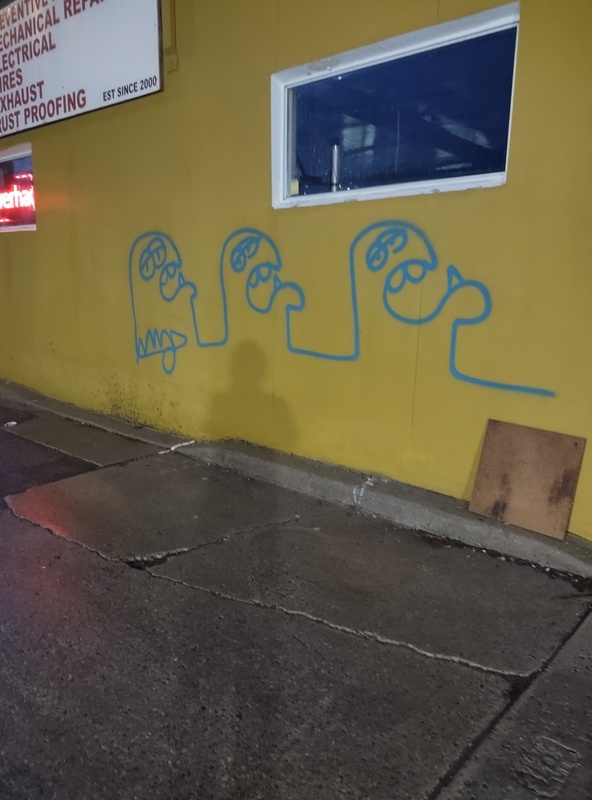 Spray painted line art of three monster heads