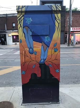 Lower body of an Indigenous woman wearing traditional dress dancing and her foot has created a crack in the earth where flowers bloom 